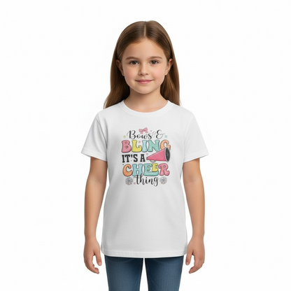 Little girl standing and modeling white Bows and Bling It’s a Cheer Thing cheerleading t-shirt with jeans